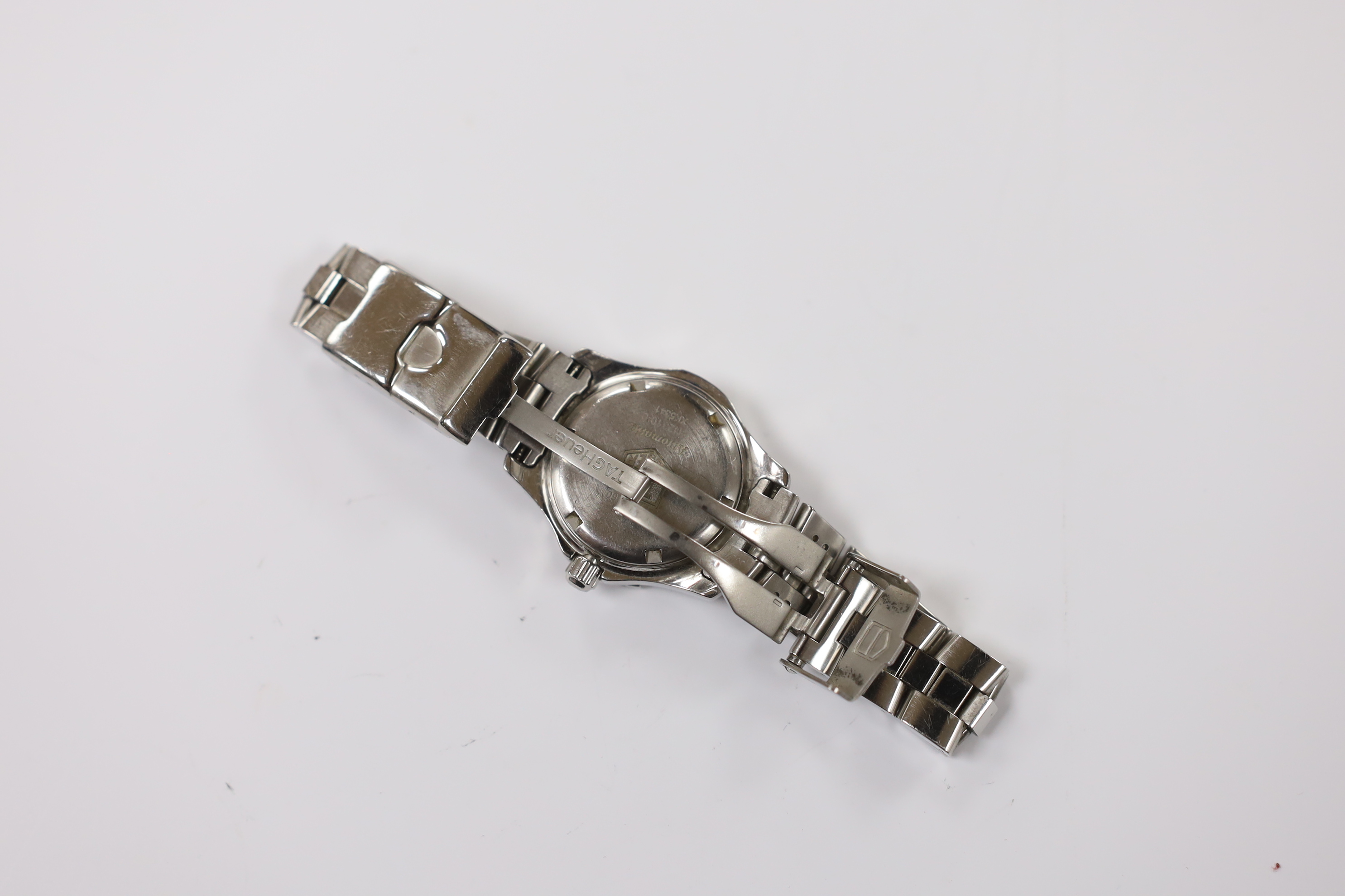 A lady's modern stainless steel Tag Heuer automatic wrist watch, with pink dial, on a Tag Heuer stainless steel bracelet. Condition - fair to poor